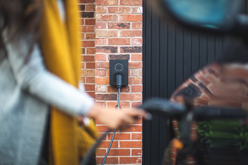 a woman is charging her bike with a charger