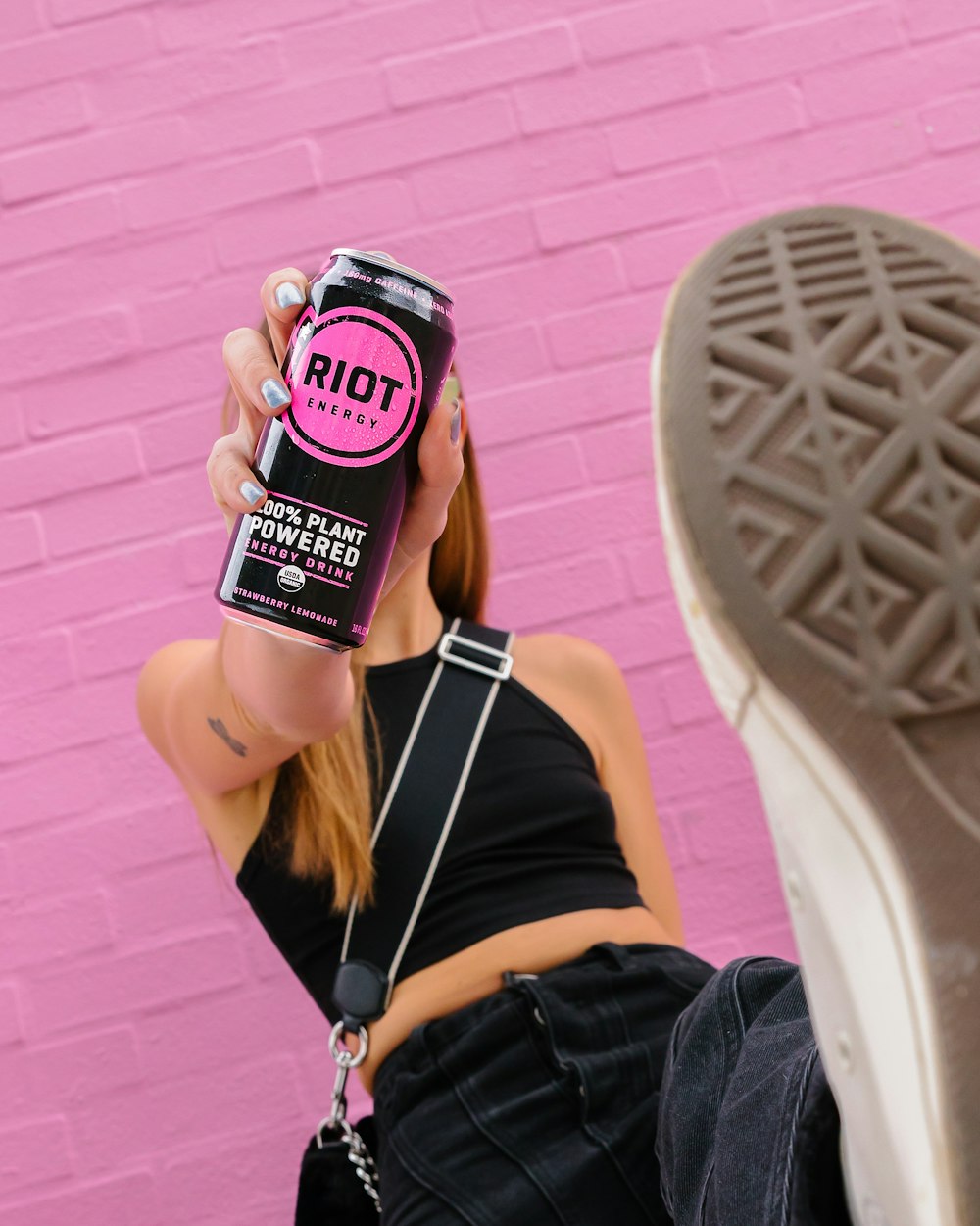 a woman holding a can of hot pink soda