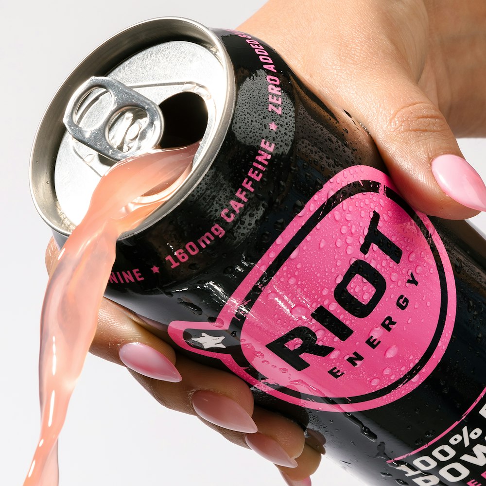 a woman's hand holding a can of soda