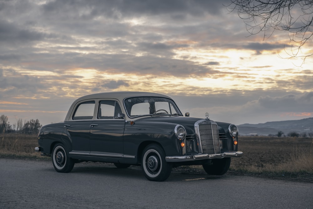 an old car is parked on the side of the road