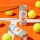Two cans of Positive Energy drink in a vibrant setting, surrounded by several yellow tennis balls on an orange and white background. An orange tennis racket is positioned to the side, creating a sporty atmosphere.
