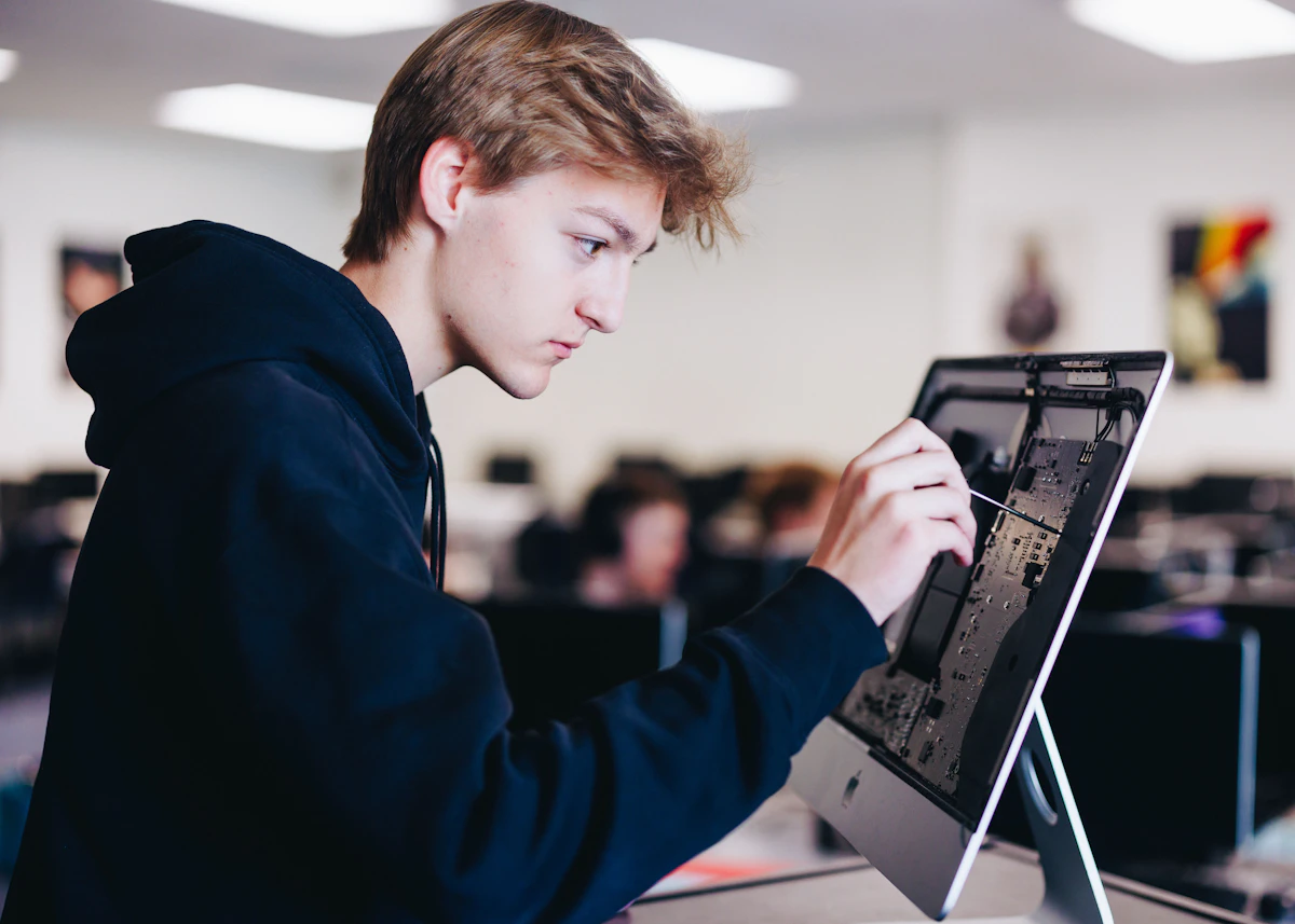 Technician working on a laptop at an office workstation