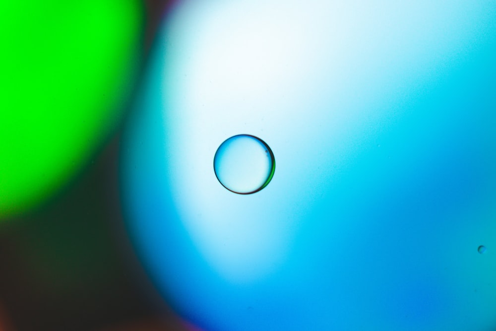 파란색과 녹색 물체 위에 앉아있는 물방울