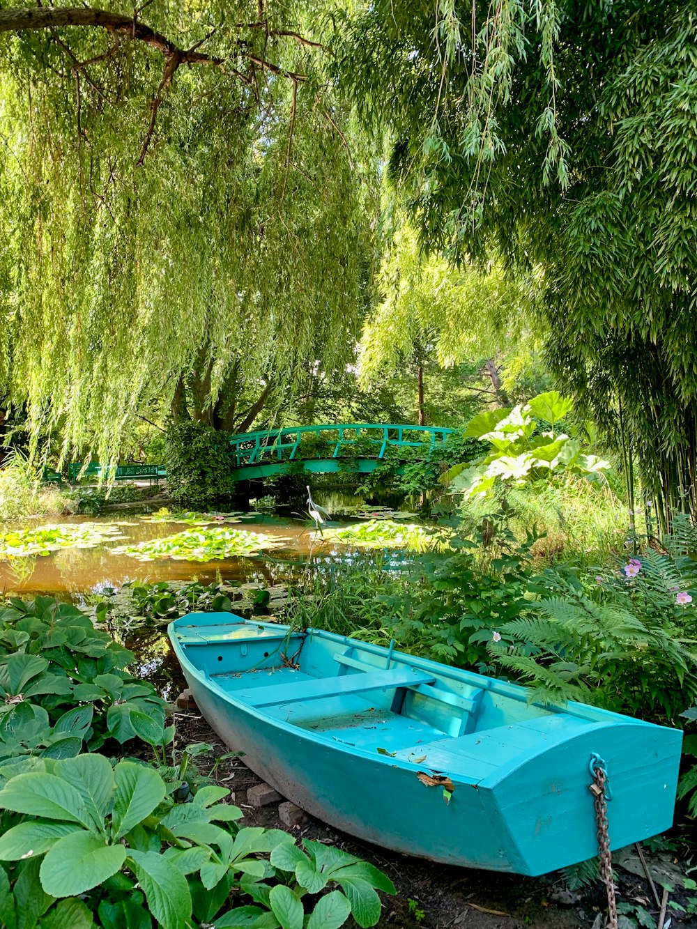 a blue boat sitting on top of a lush green field