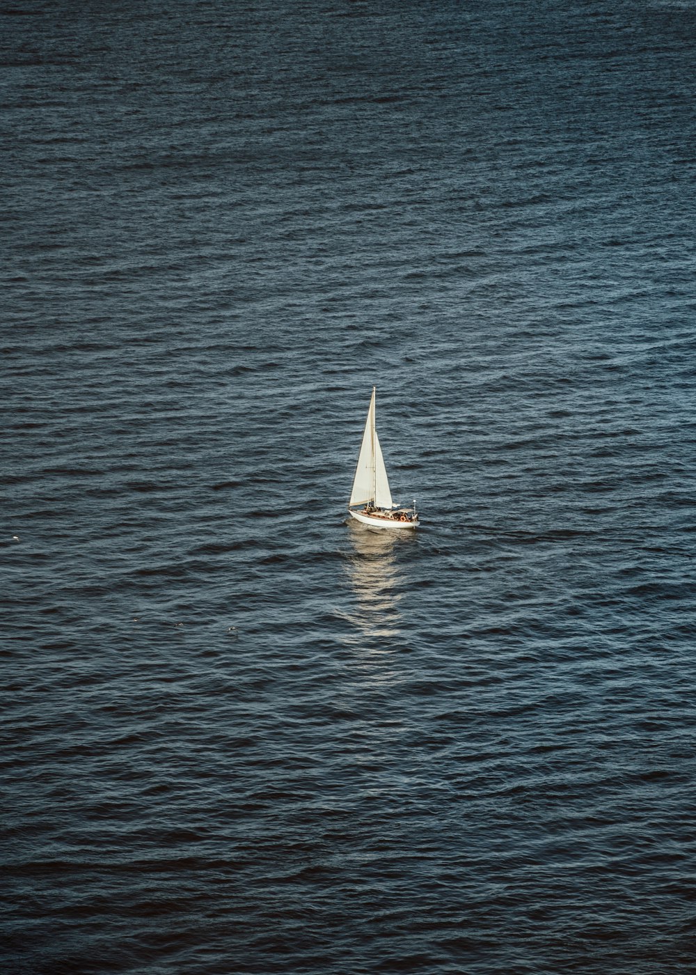 a small sailboat floating on top of a large body of water