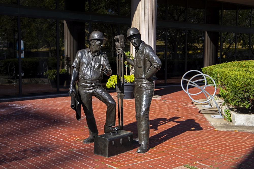 uma estátua de dois homens sentados um ao lado do outro