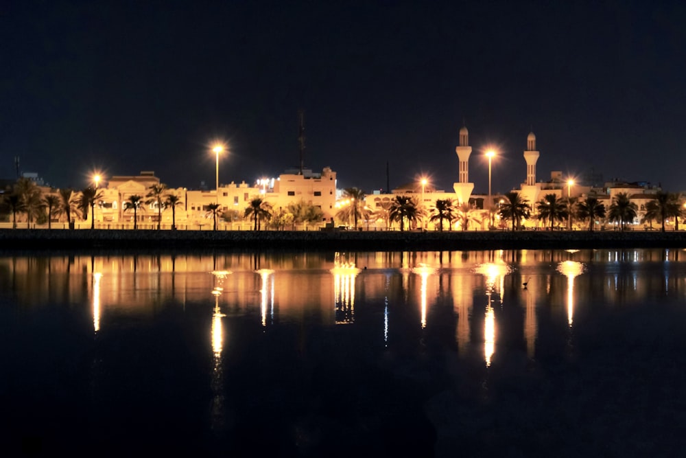 a night view of a city with lights reflecting in the water