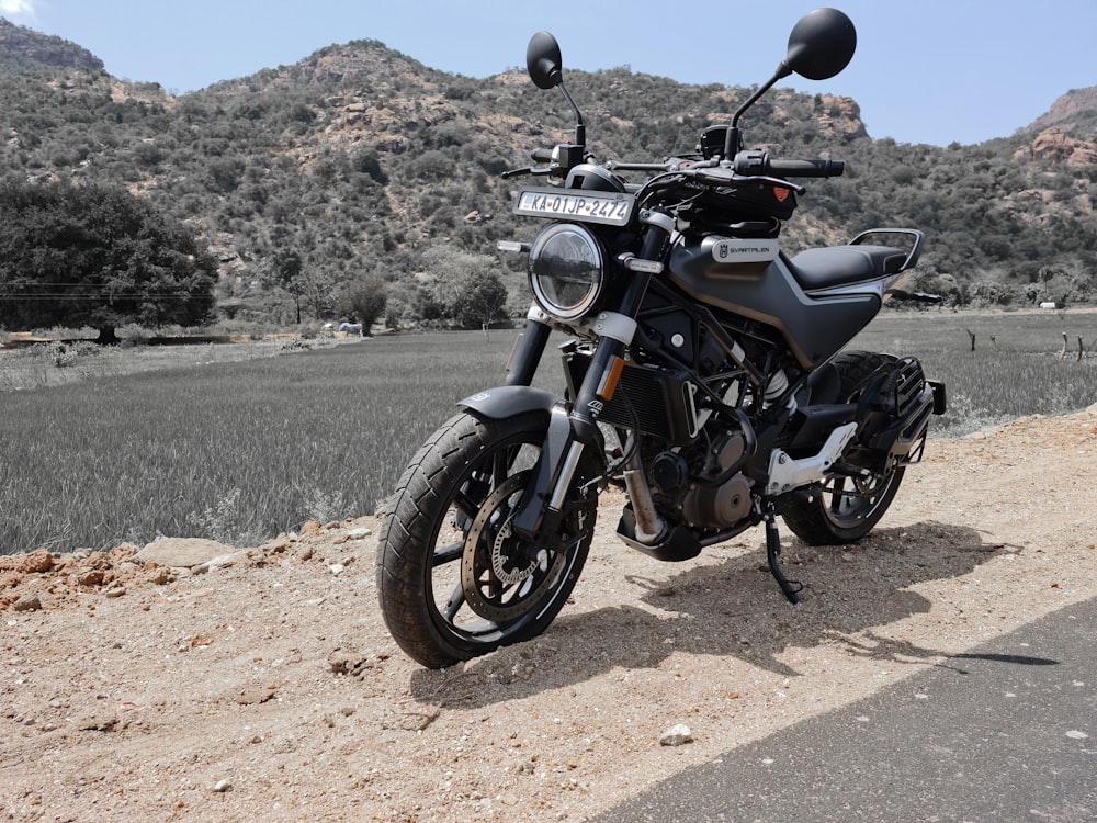 Una motocicleta estacionada al costado de un camino de tierra