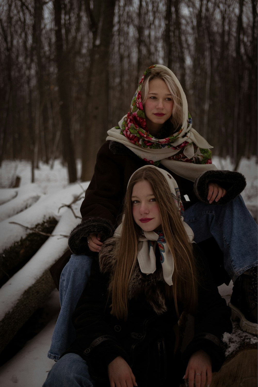 a couple of women sitting next to each other in the snow