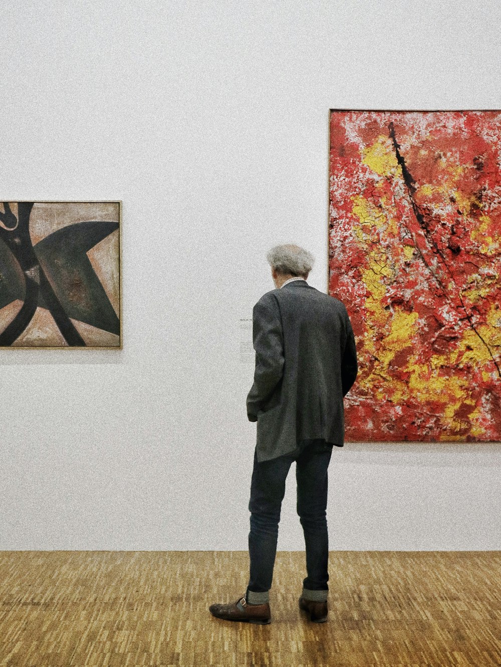 a man standing in front of a painting in an art gallery