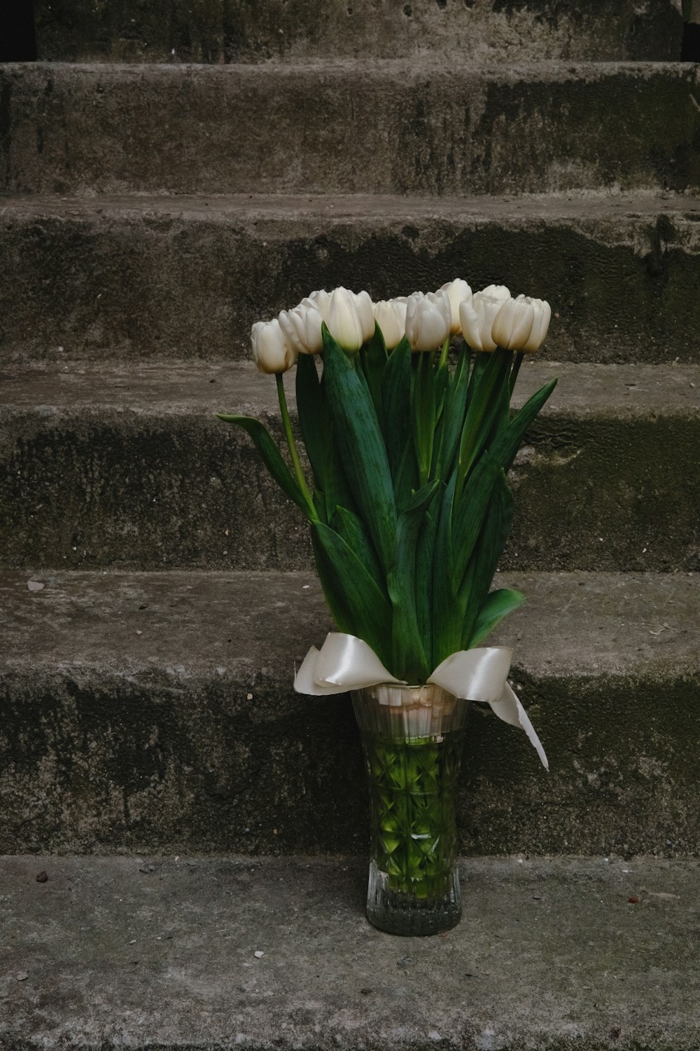 계단에 꽃병에 흰 튤립 꽃다발