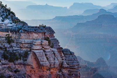 Wide shot of layered canyon landscapes with soft gray mist in the distance.
