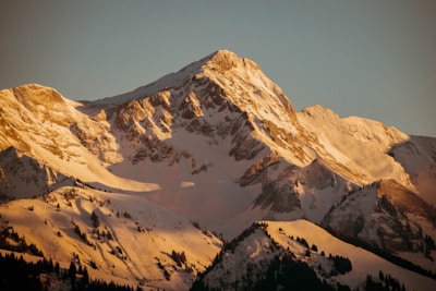 a mountain covered in snow with a sky background