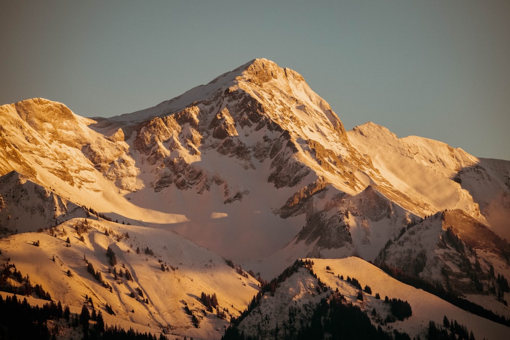 a mountain covered in snow with a sky background