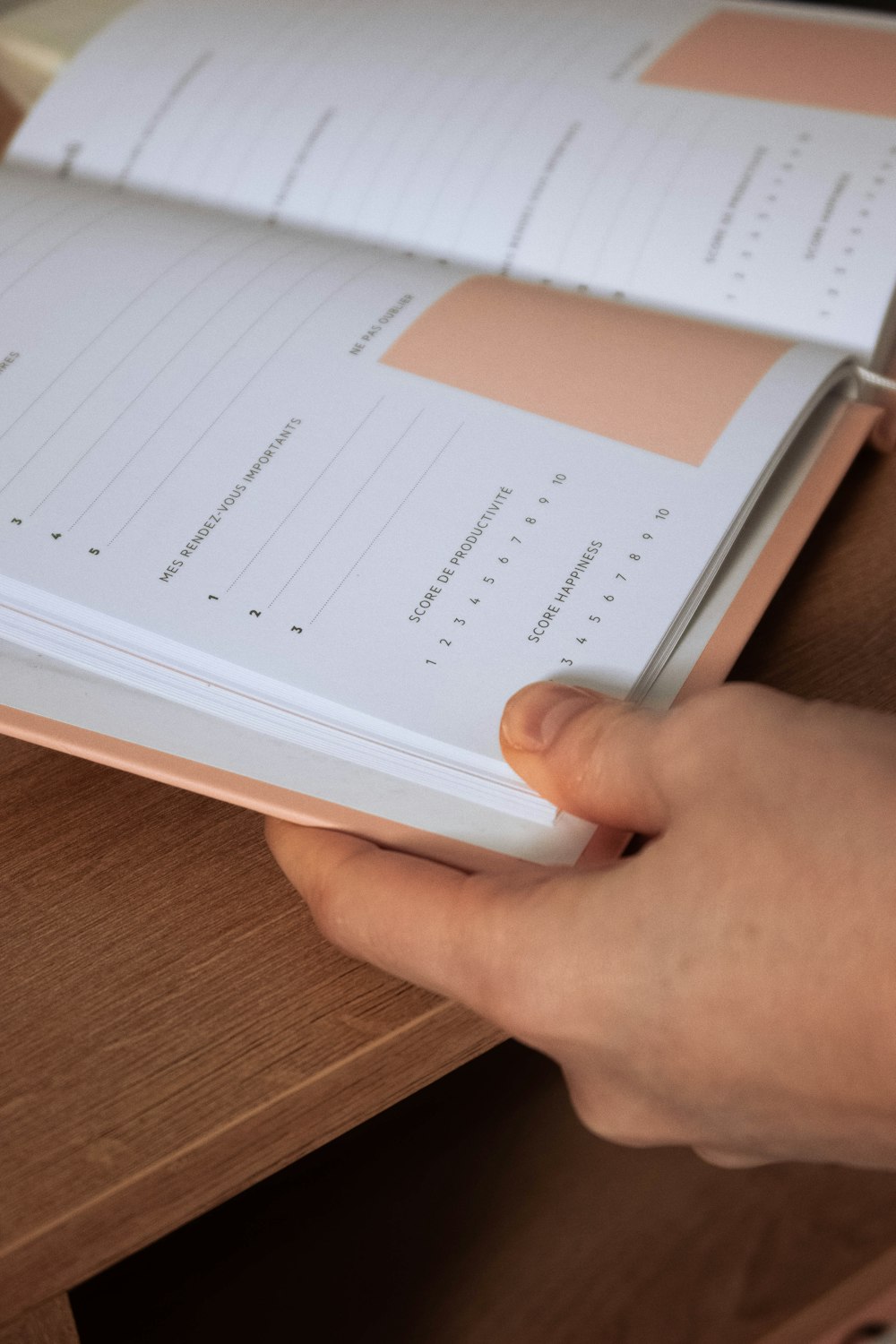 a person is holding a book open on a desk