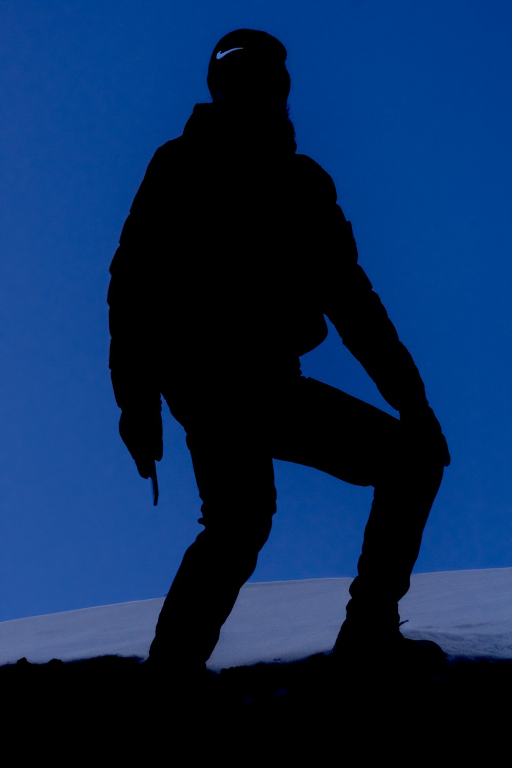 a silhouette of a person standing on a hill