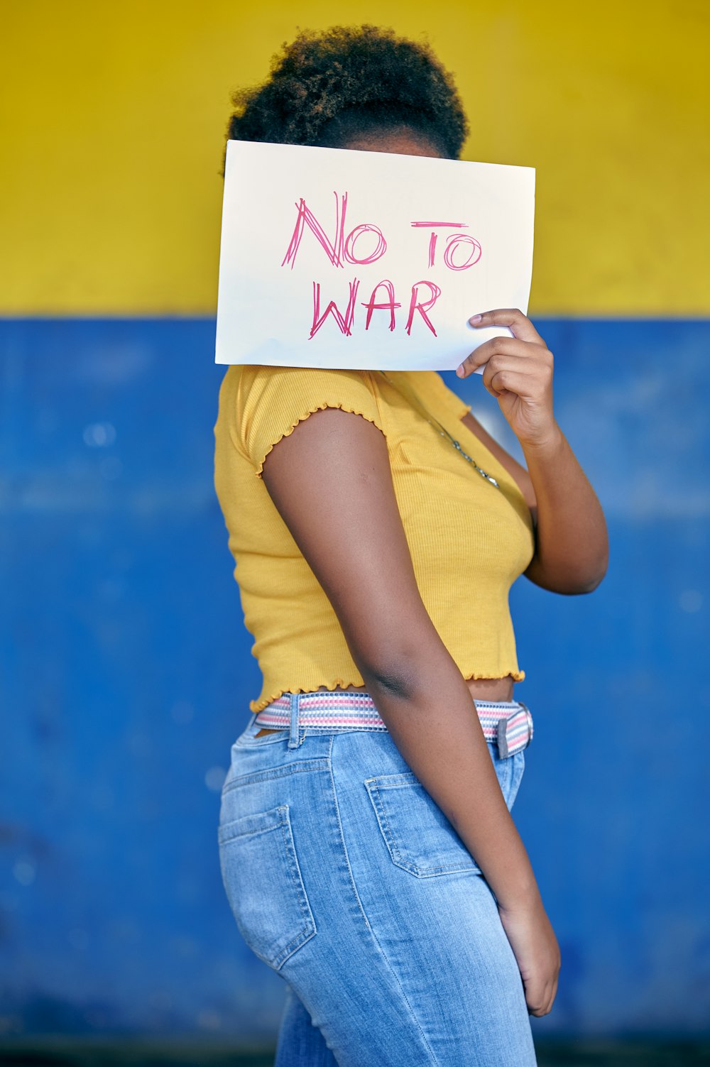 a woman holding a sign that says no to war