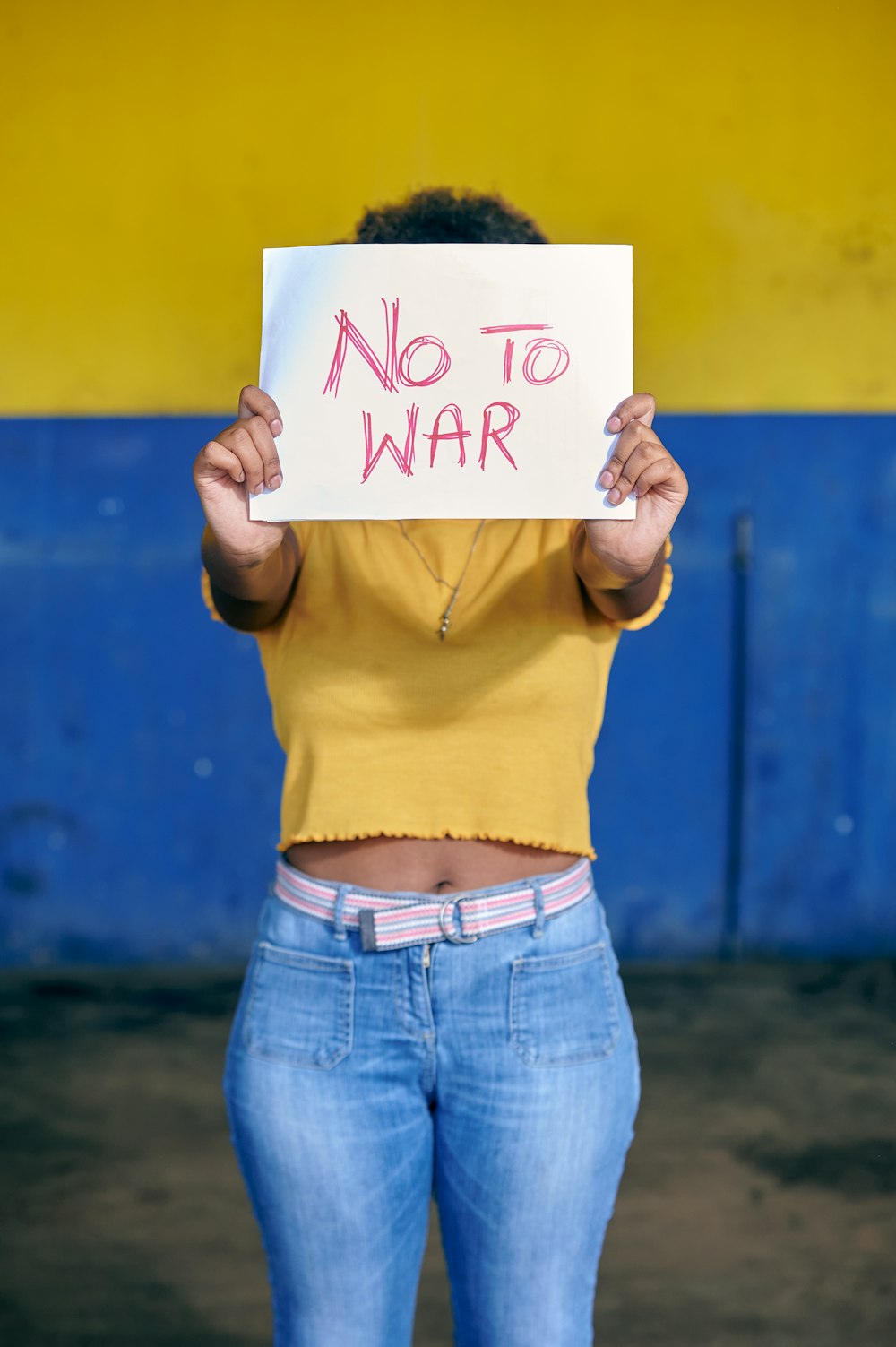 a woman holding a sign that says no to war