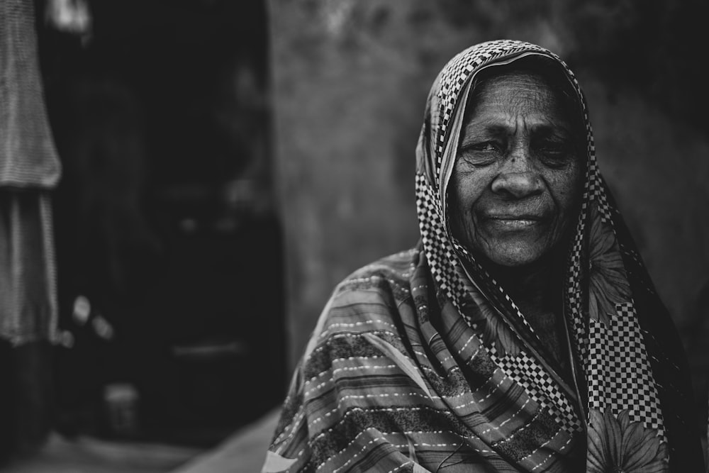 a black and white photo of a woman in a scarf