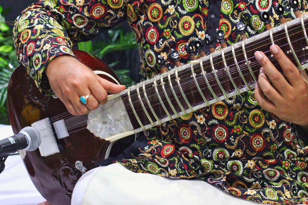 a man in a colorful shirt playing a guitar