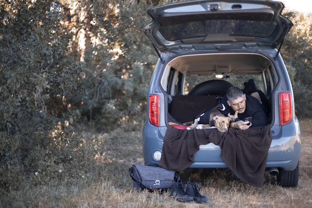 a man sitting in the back of a blue van