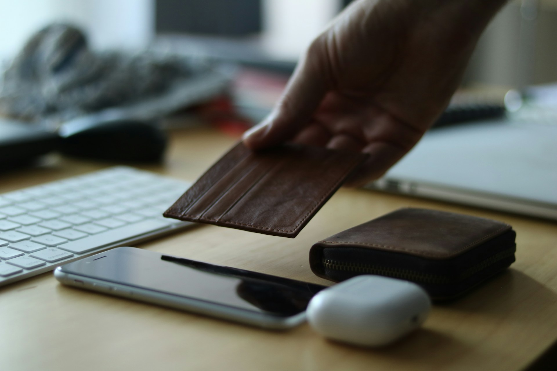 a person holding a wallet near a keyboard