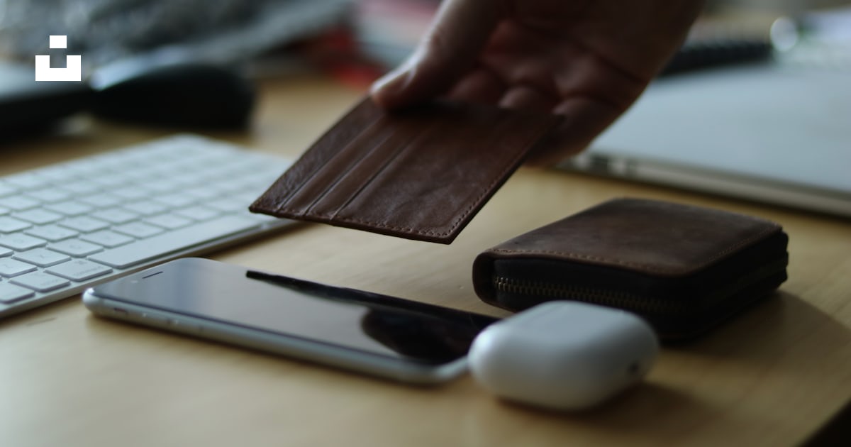 A person holding a wallet near a keyboard photo – Free Money Image on ...