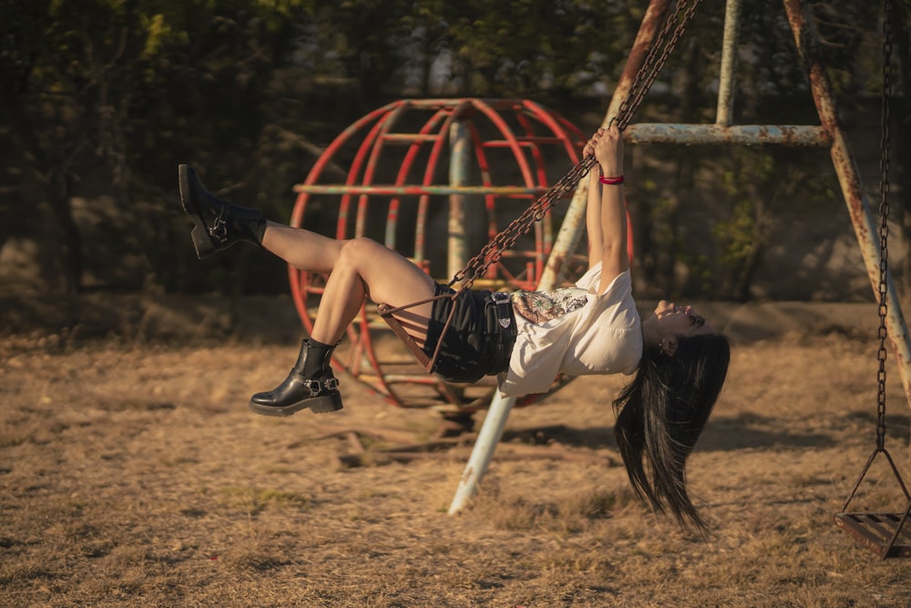 a woman is swinging on a swing set