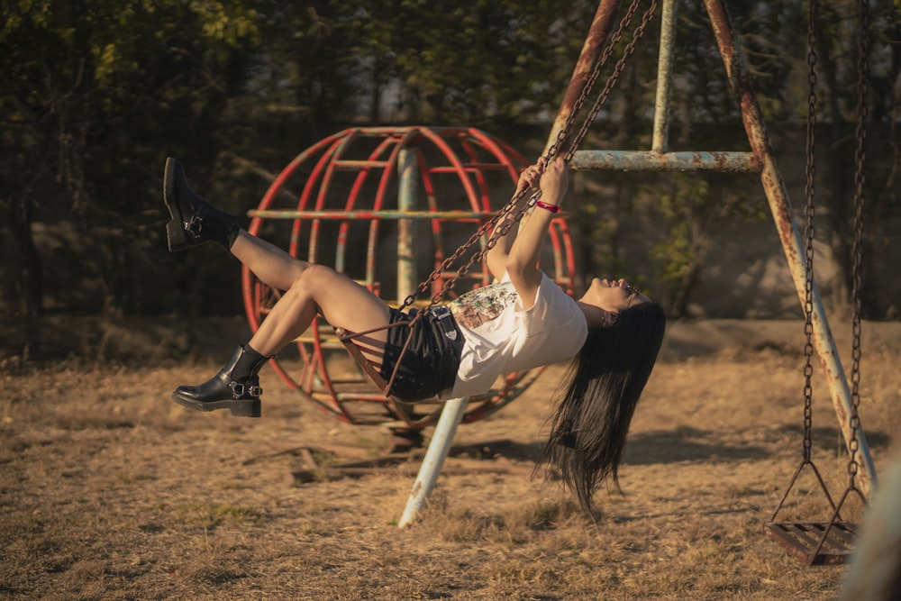 a girl is swinging on a swing set