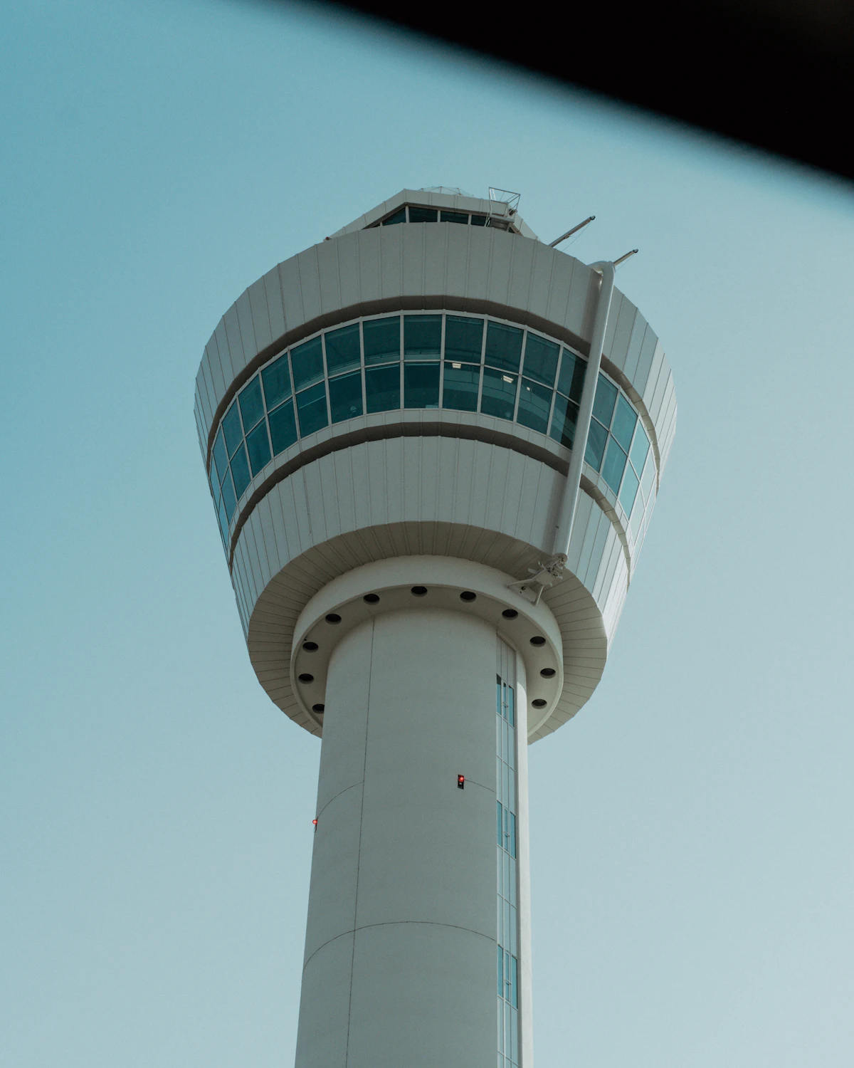An airport control tower overlooking runways at dusk