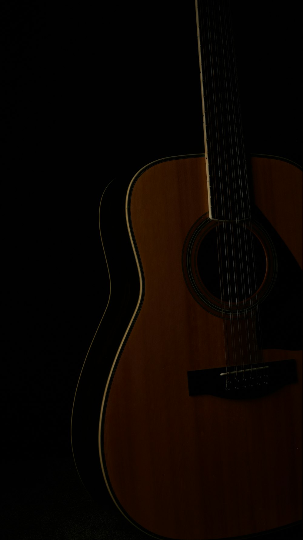 Gros plan d’une guitare dans le noir