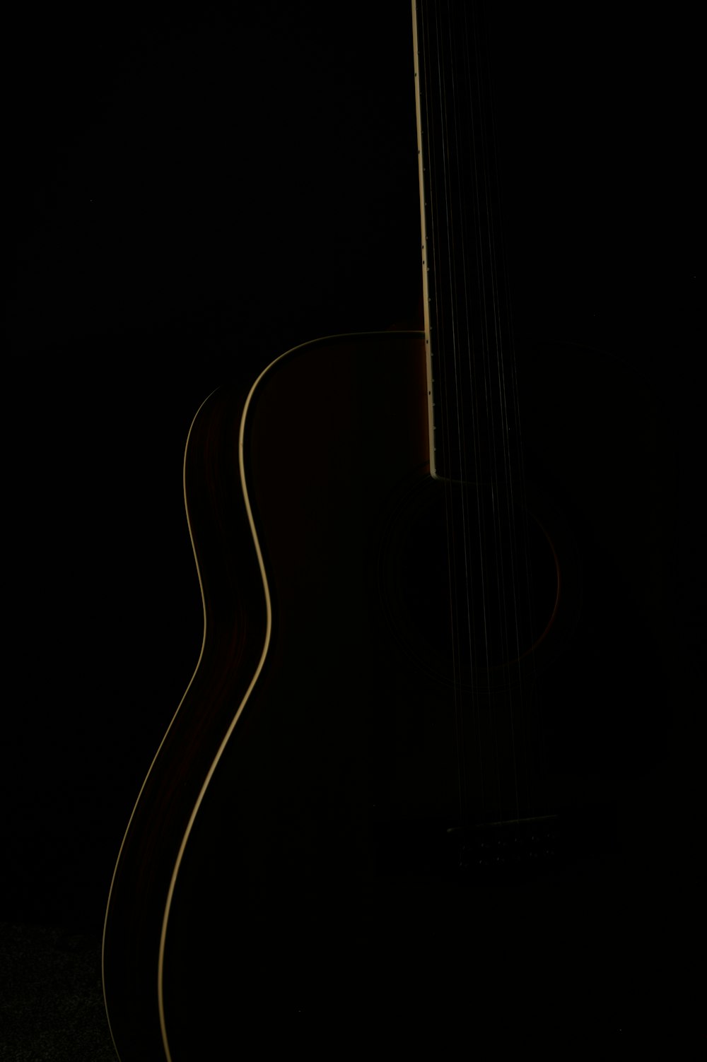 an acoustic guitar is lit up in the dark