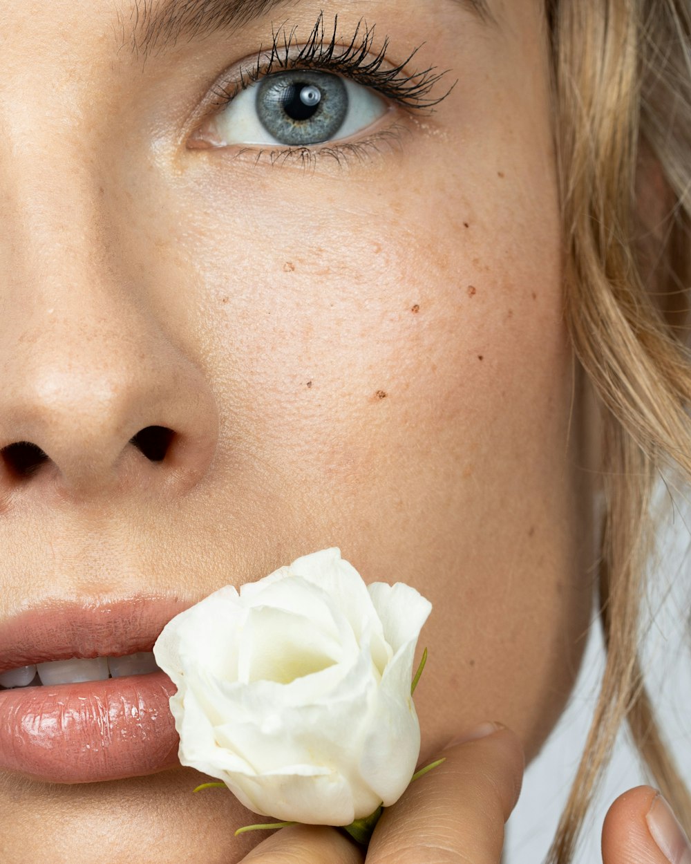 a close up of a person holding a flower