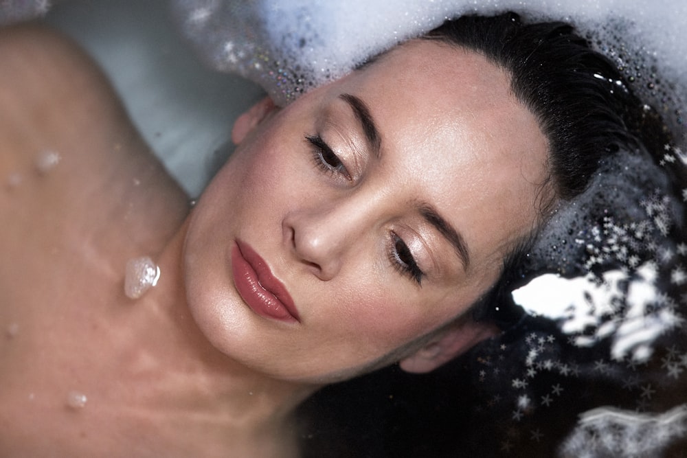 a woman taking a bubble bath in a bathtub