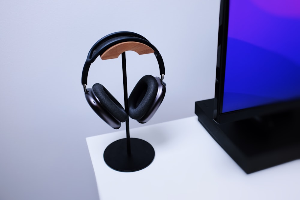 a pair of headphones on a stand next to a monitor