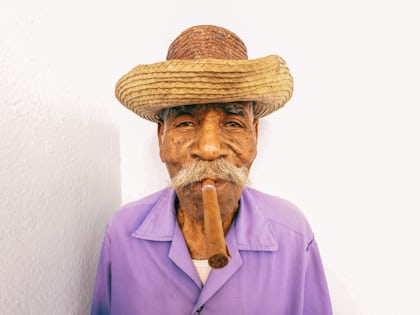 a man wearing a straw hat and a pipe photo – Free White Image on Unsplash