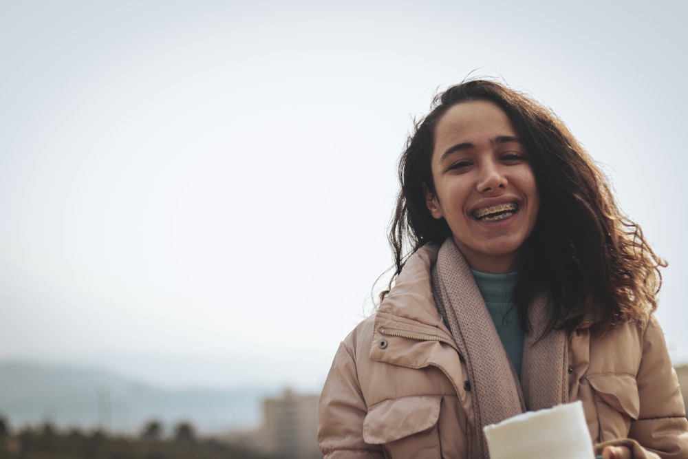 a woman holding a cup of coffee and smiling