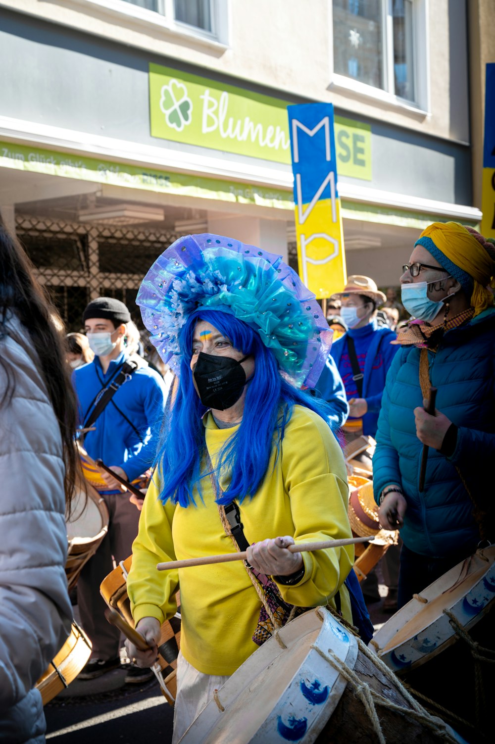 a woman with blue hair and a face mask