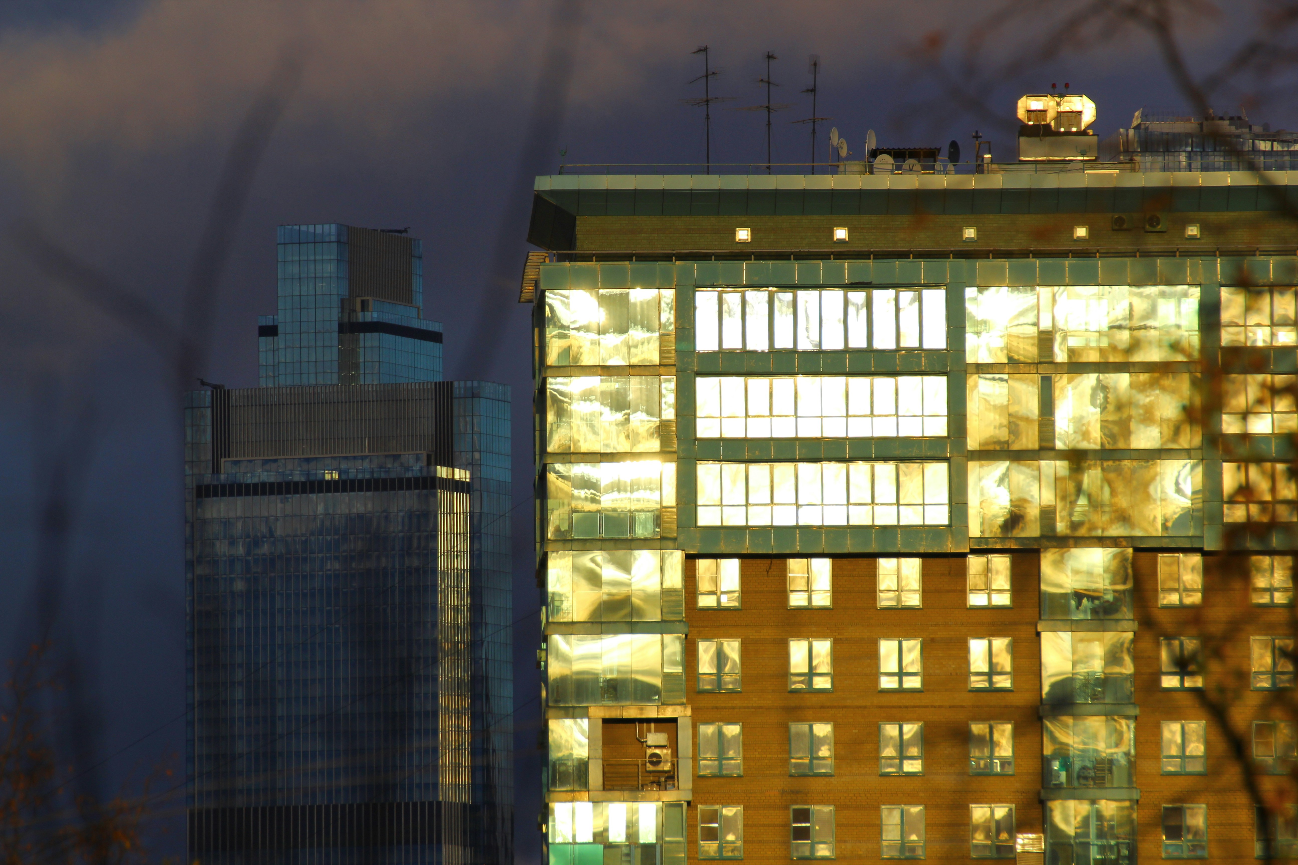 Luxury modern home exterior at dusk, clean architectural lines, bright windows, dark sky background