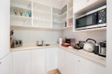 Compact kitchen area with essential appliances and utensils neatly arranged.