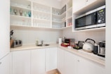 a kitchen with white cabinets and a microwave