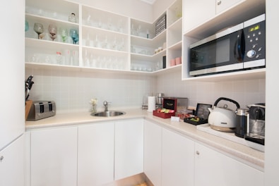 Modern kitchenette area with coffee maker and utensils