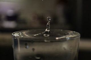 a drop of water falling into a glass of water