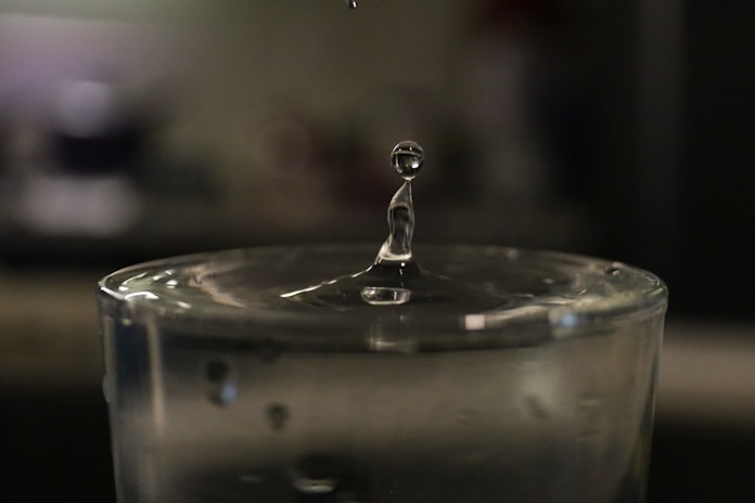 a drop of water falling into a glass of water