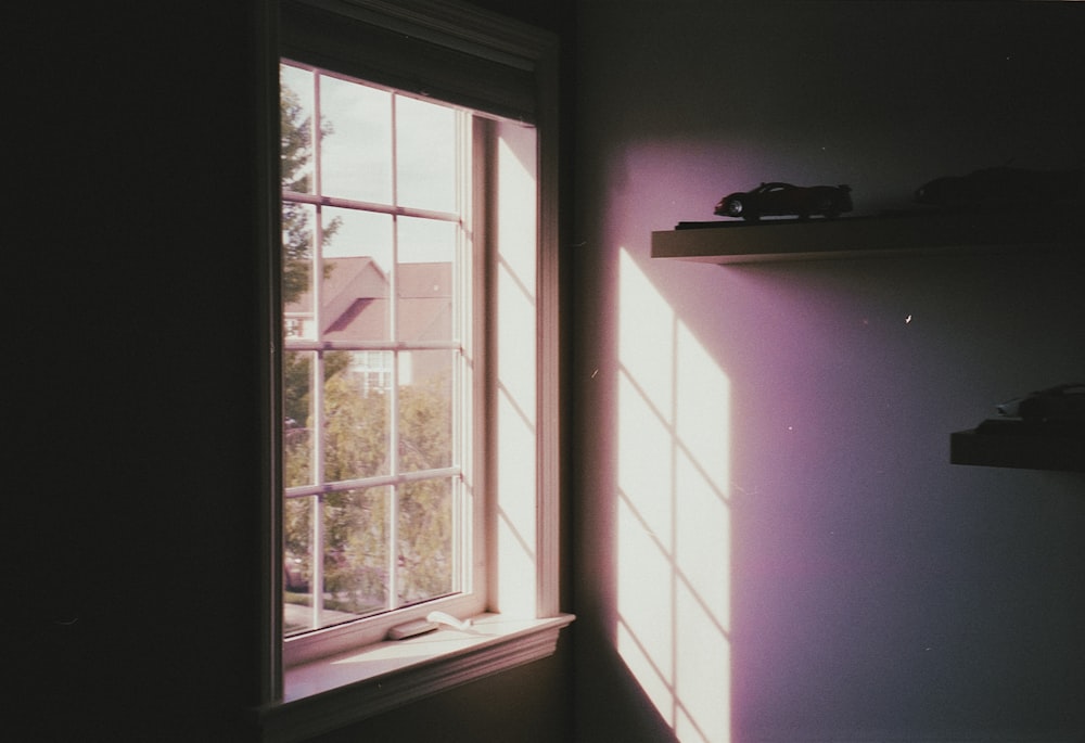 a room with a window and a shelf on the wall