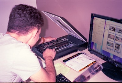 a man sitting at a desk using a laptop computer