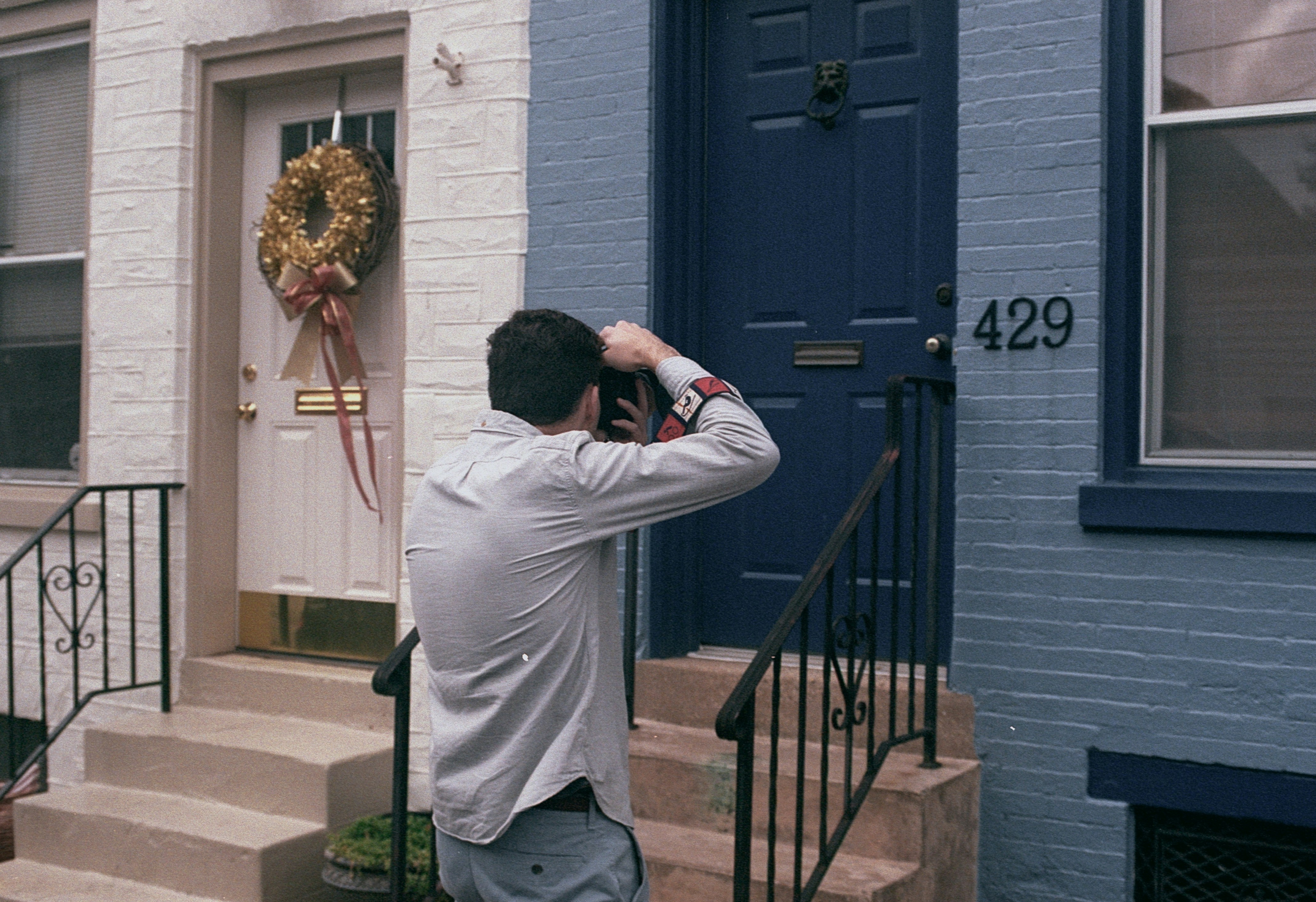This photo shows a man taking a picture of a plain door