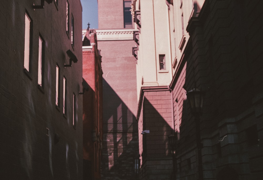 a narrow alley way with a clock tower in the background