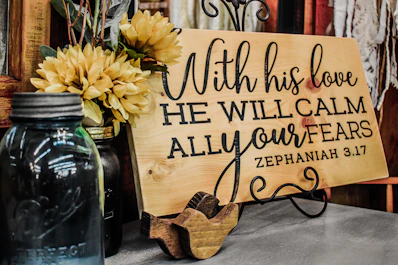 a wooden sign that says with his love he will calm all your tears
