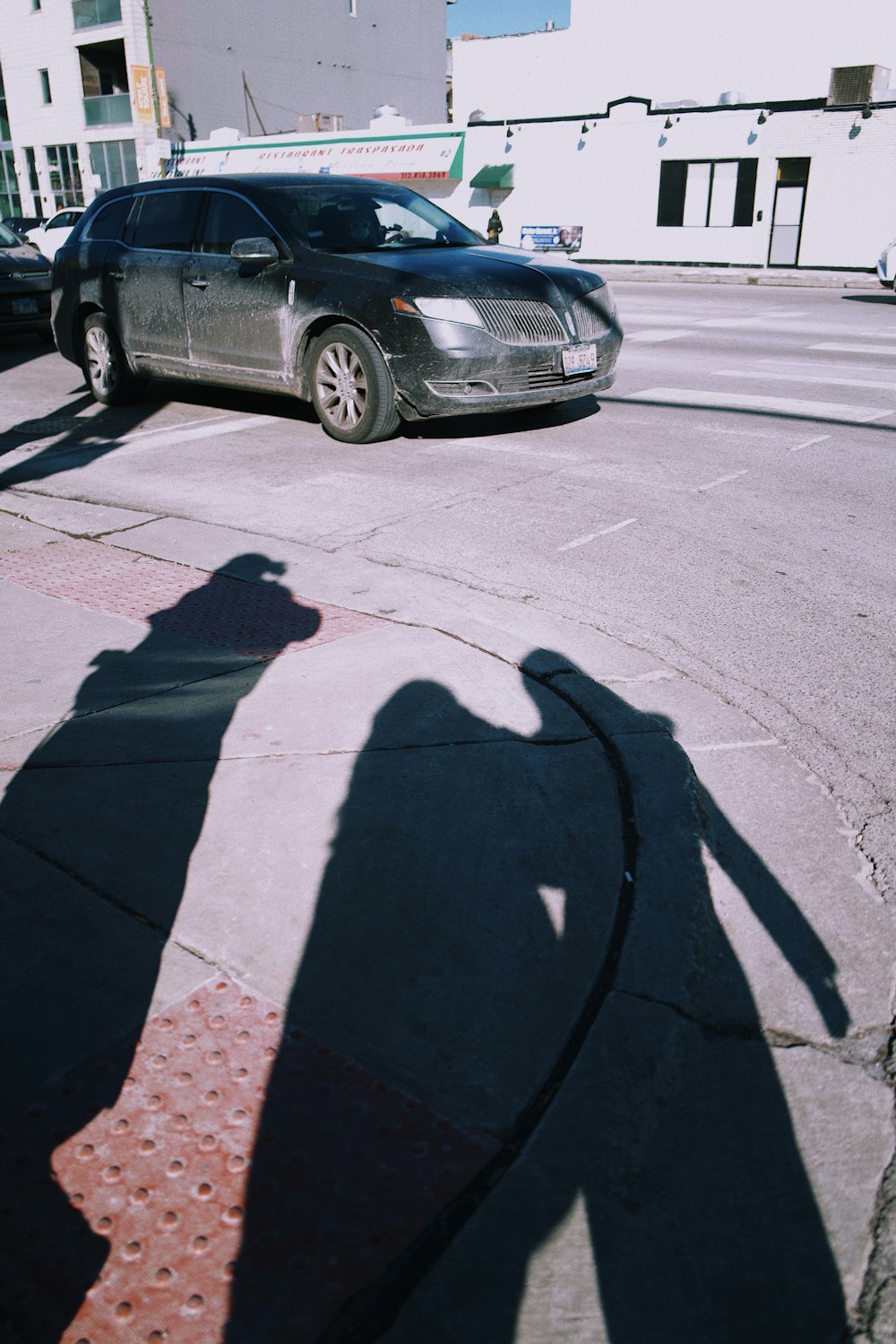 a shadow of a person standing next to a car